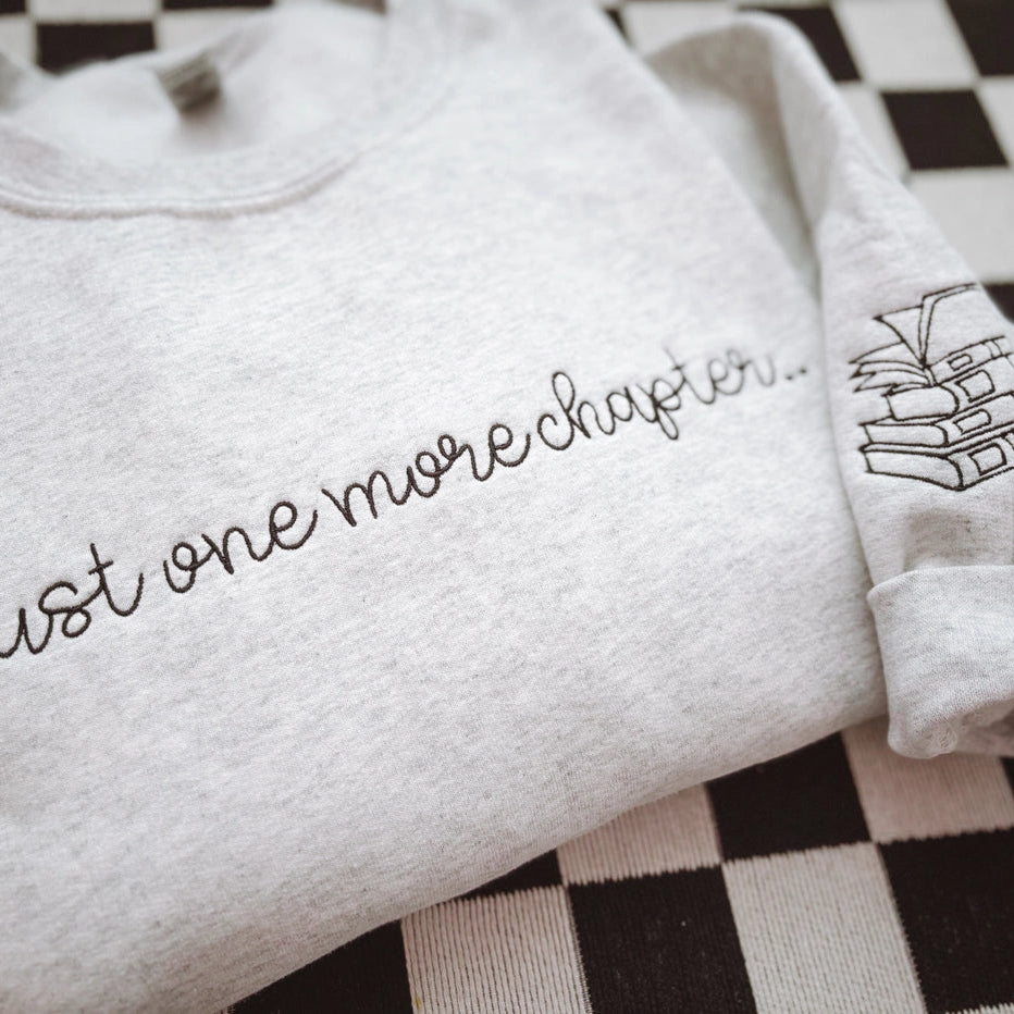 One More Chapter Embroidered Crewneck Sweatshirt – Cozy Book Lover Gift by Graphic tee and co.