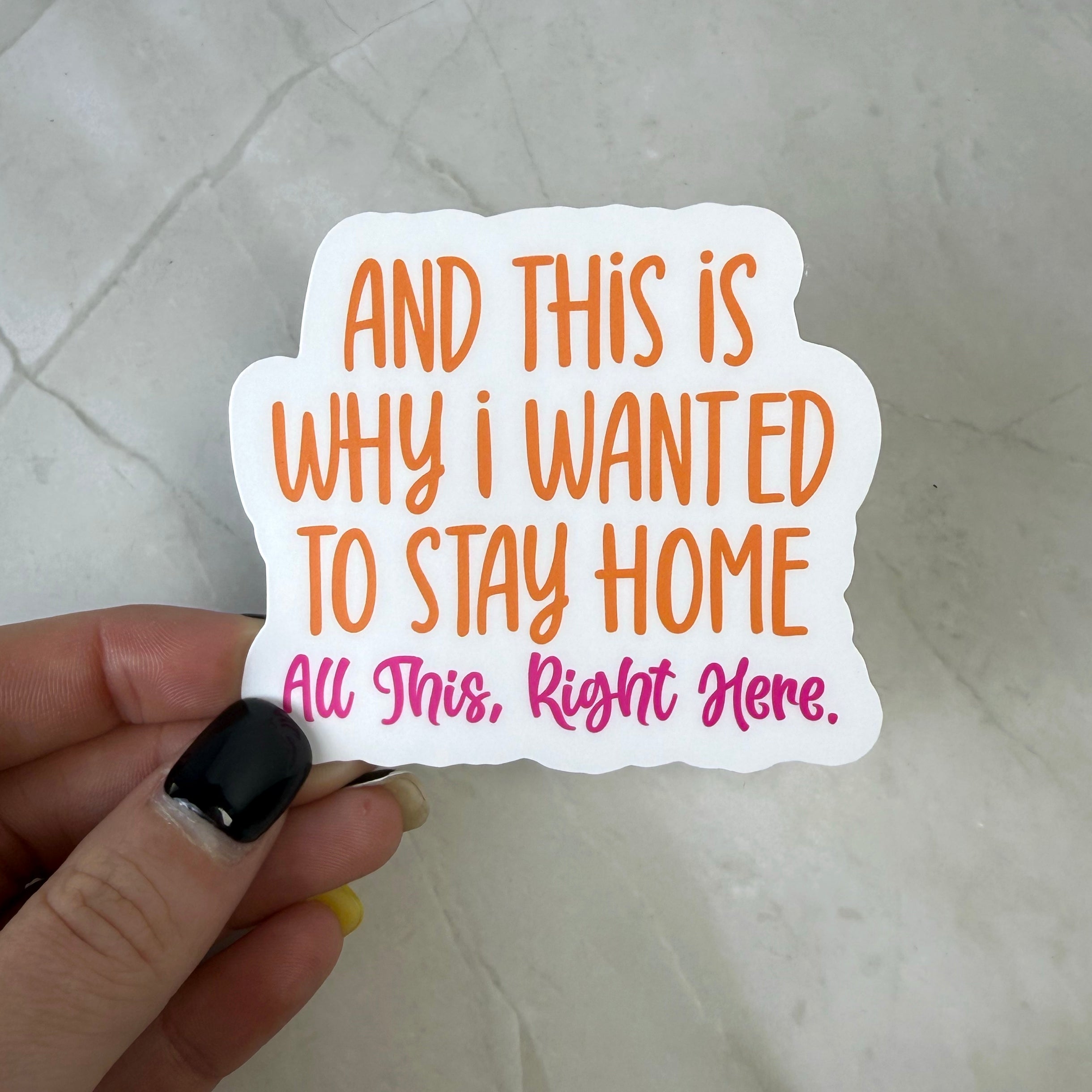 Hand holding a white sticker with text on a light gray background