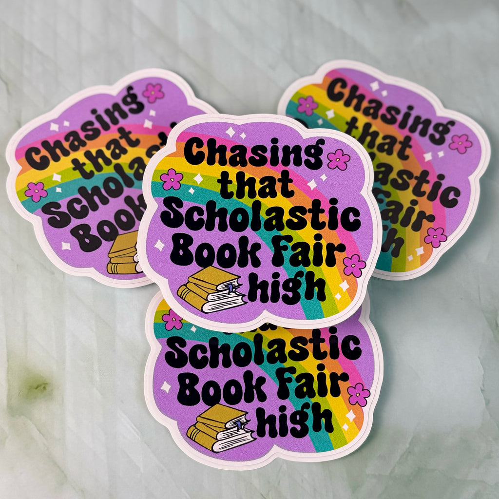 Three colorful stickers with text 'Chasing that Scholastic Book Fair high' on a gray background.