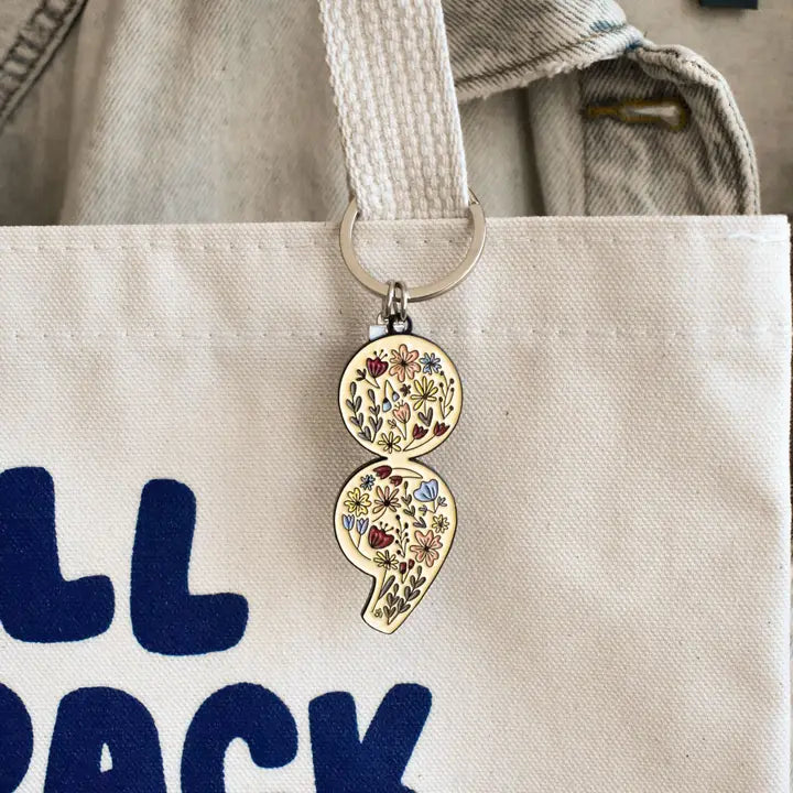 Keychain with floral design attached to a tote bag