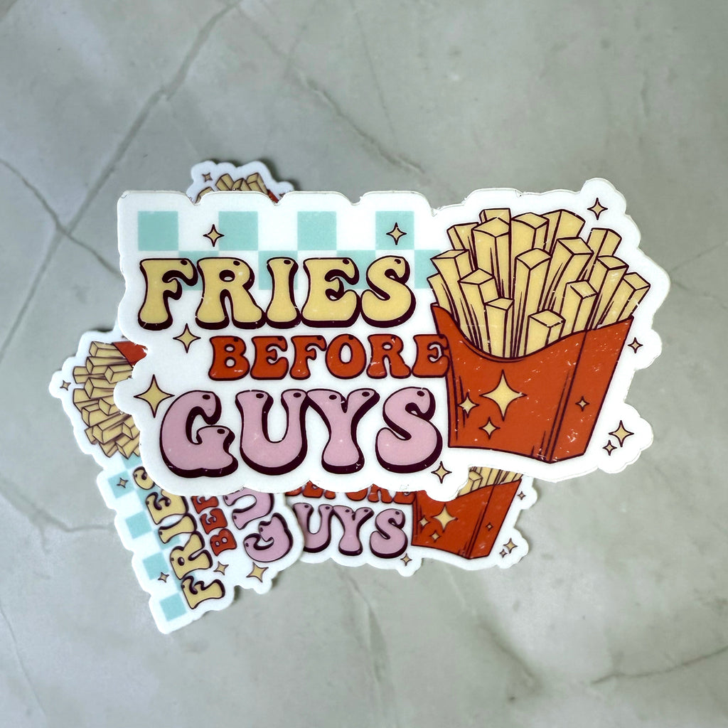 Sticker with 'Fries Before Guys' text and cartoon fries on a textured surface