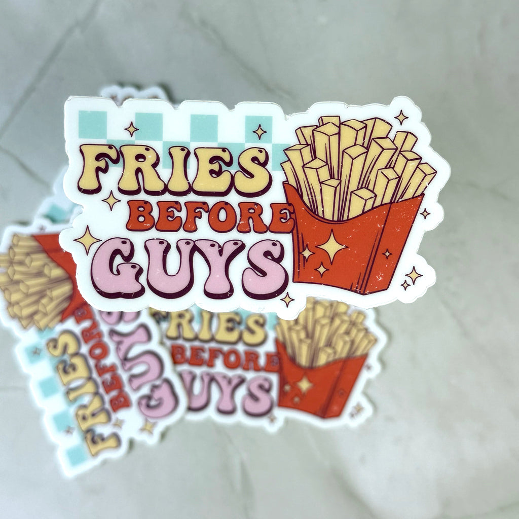 Sticker with 'Fries Before Guys' text and French fries illustration on a textured surface.