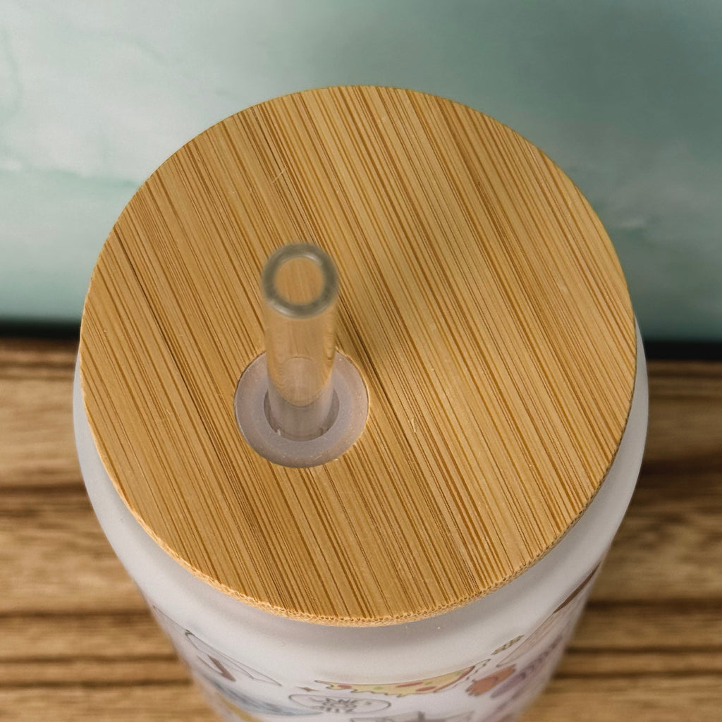 Close-up of a white mug with a bamboo lid on a wooden surface.
