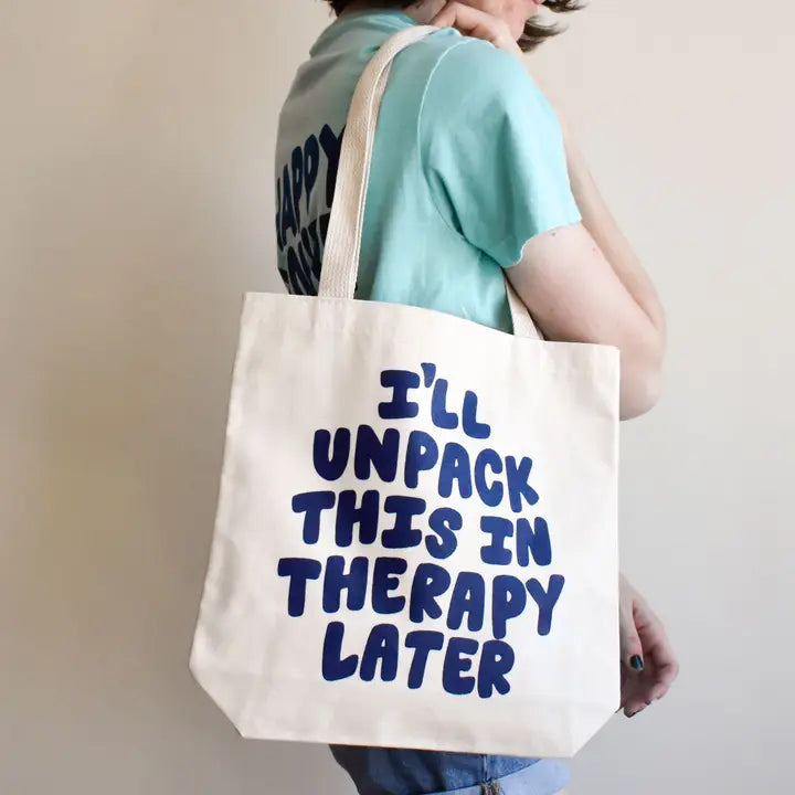Person holding a tote bag with 'I'll unpack this in therapy later' text.