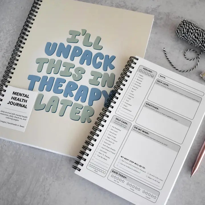 Mental health journal with 'I'll unpack this in therapy later' text on a gray surface.