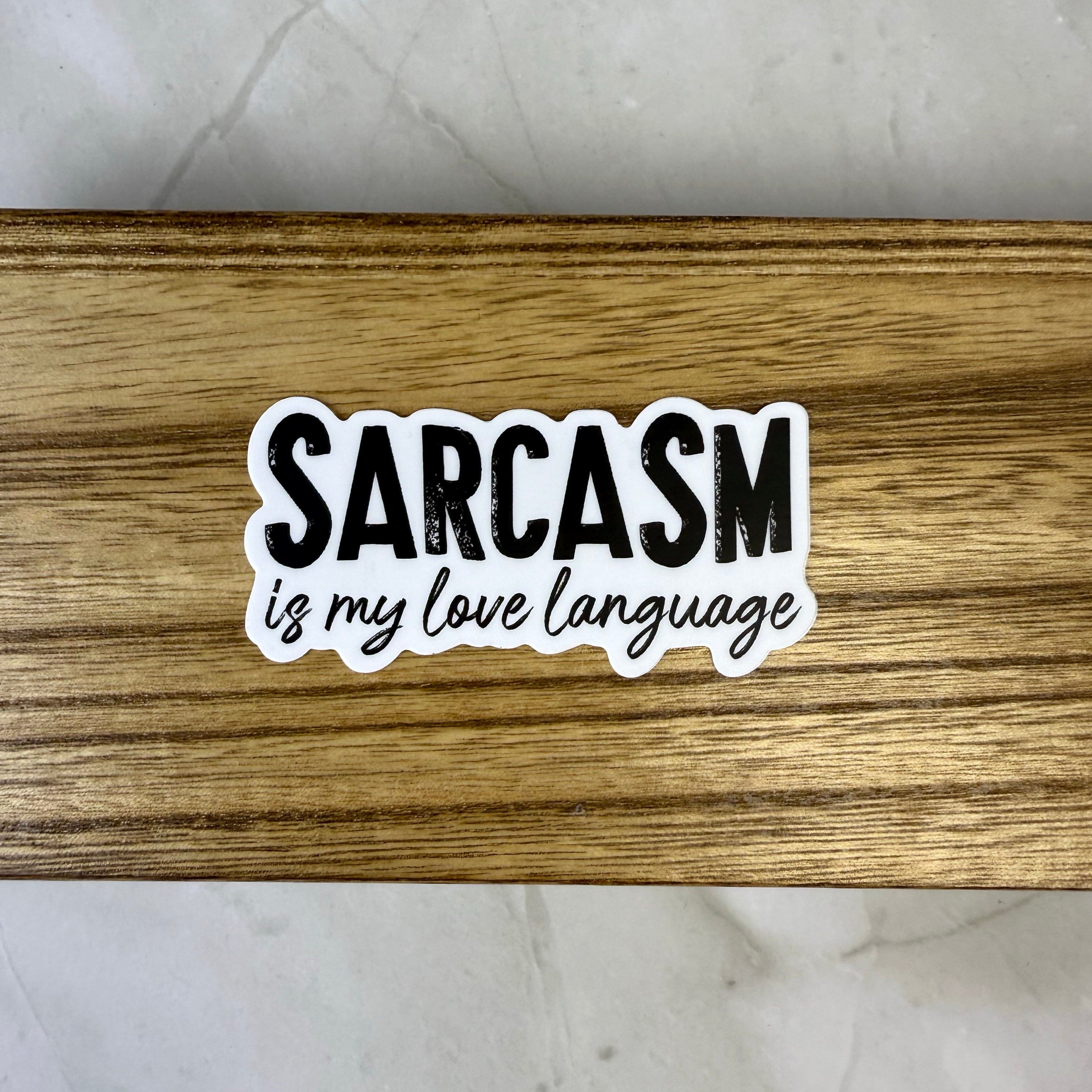 Sticker with 'Sarcasm is my love language' text on a wooden surface