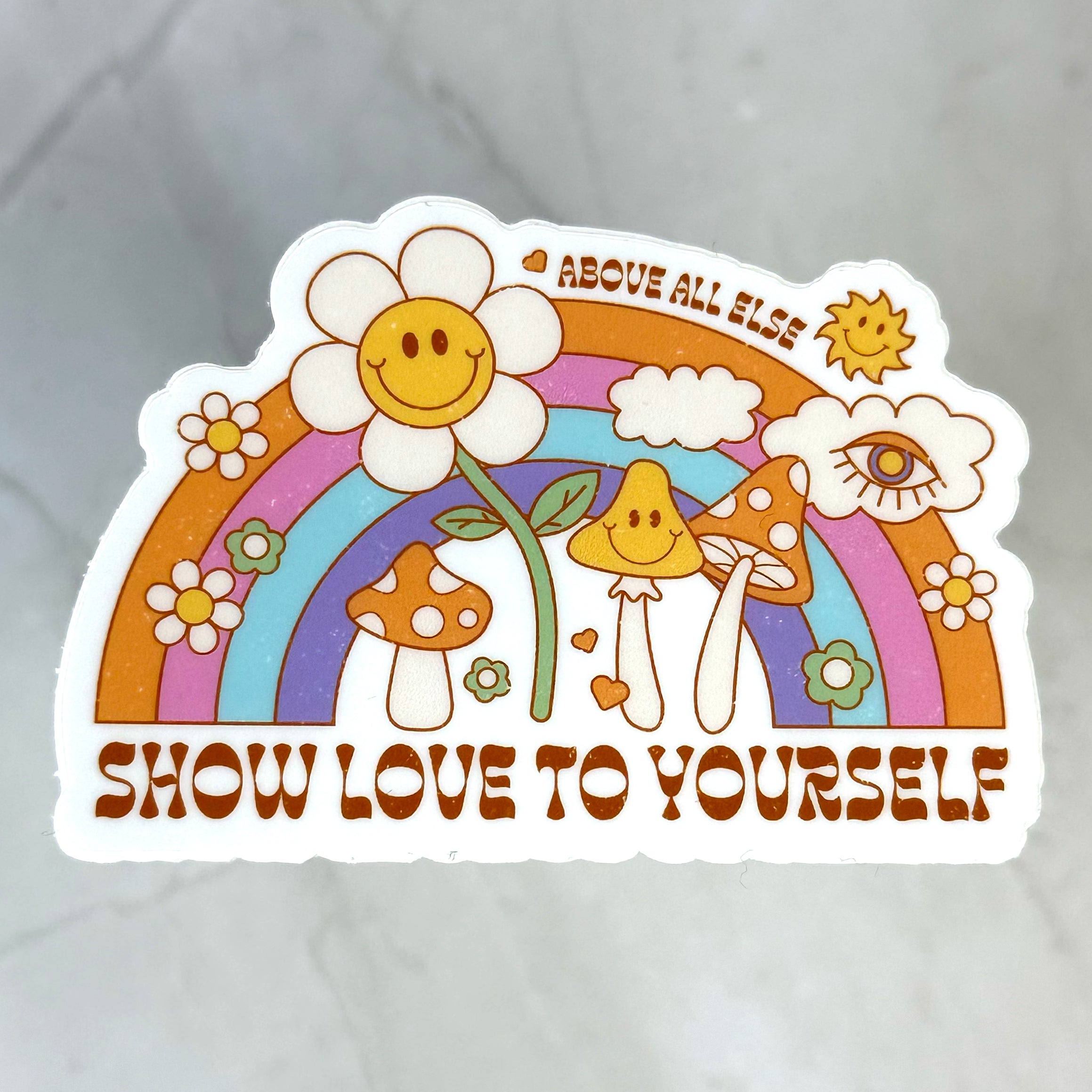 Sticker with smiley face flowers, rainbow, and motivational text on a gray background