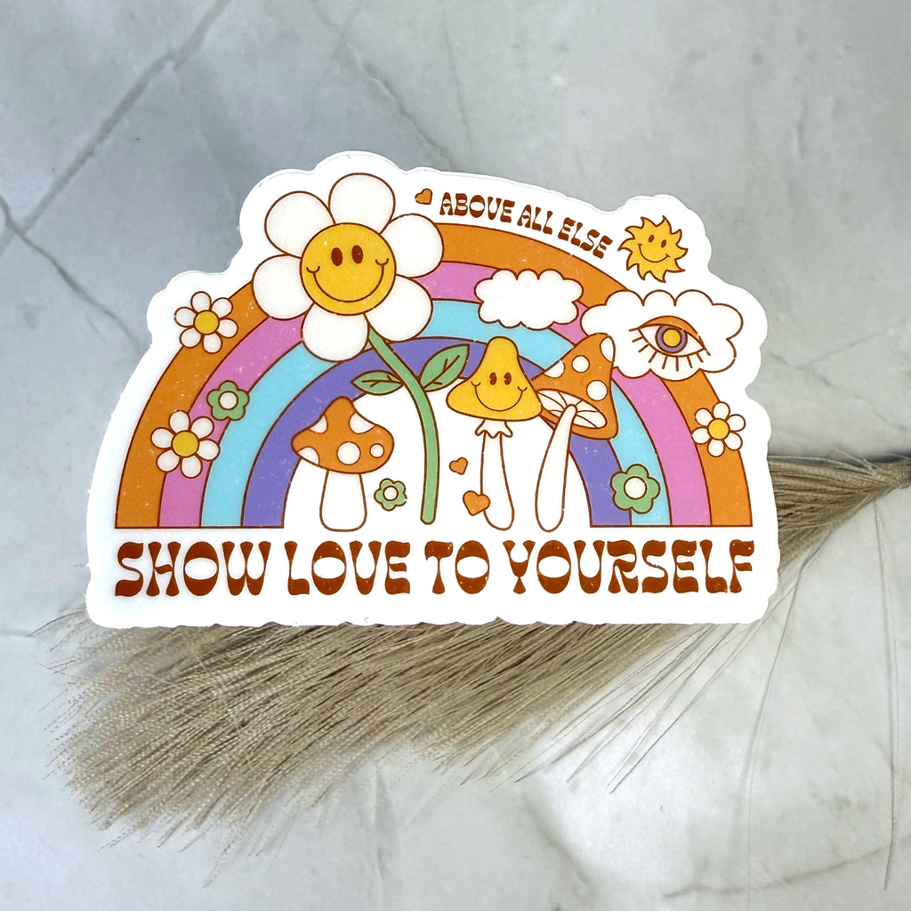 Sticker with a rainbow, flowers, and mushrooms on a gray surface